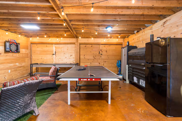 Ping pong table in the game barn under string lights