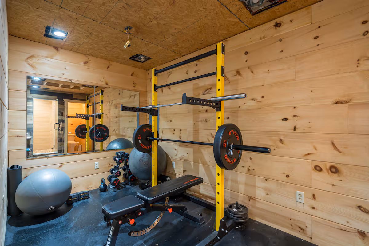 On-site home gym with squat rack, dumbbells and bench